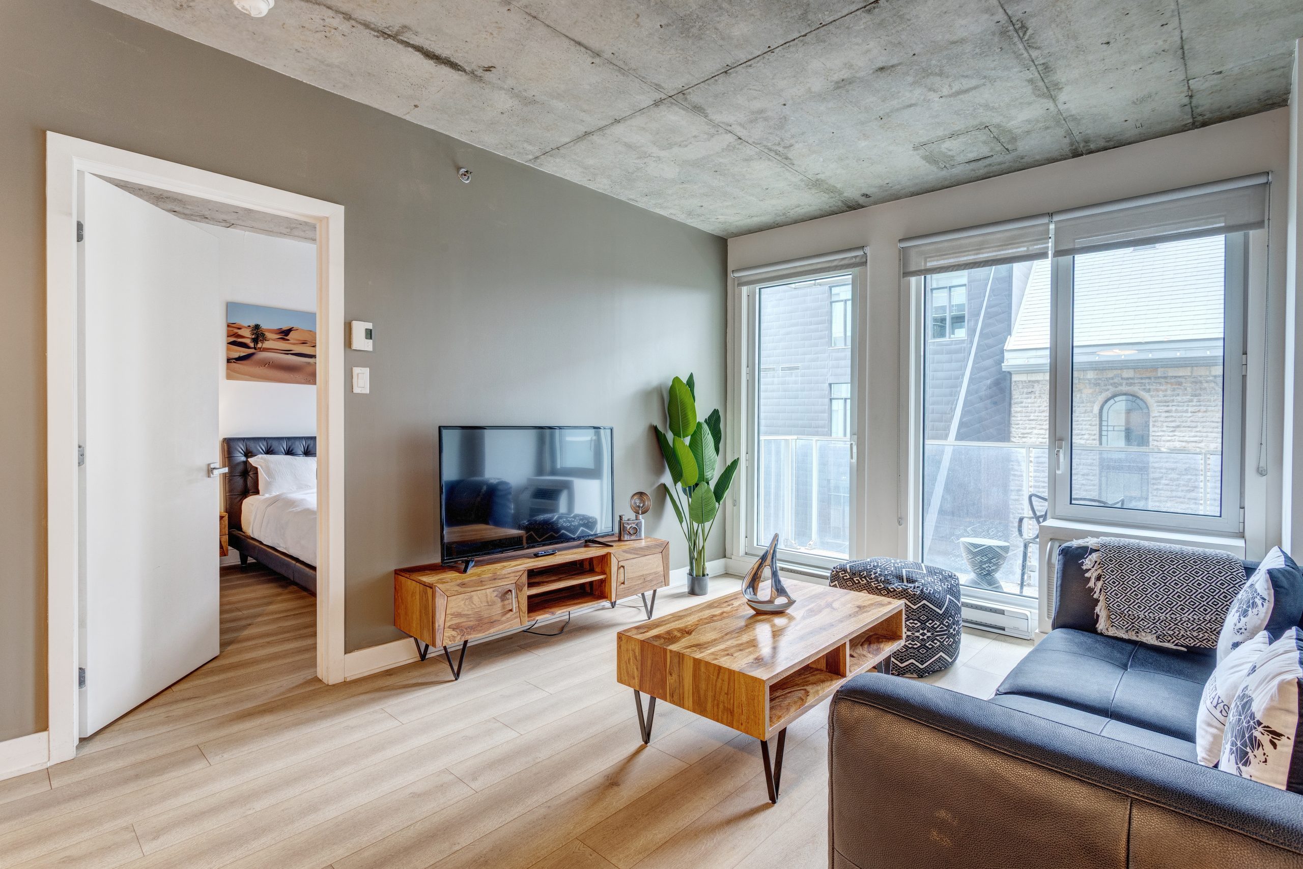 Spacious and modern living room in a fully furnished apartment by Montreal Stays, featuring comfortable seating, large windows, stylish décor, and ample natural light in Montreal.